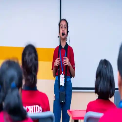 A student delivering a speech on stage, practicing public speaking skills.